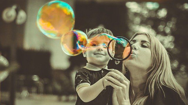 Madre e hijo jugando con un soplador de burbujas - COVID19 y régimen de visitas